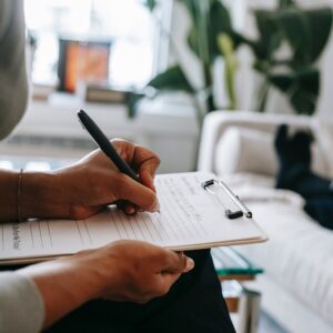 therapist completing assessment while client lays on couch, only feet visible