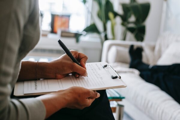 therapist completing assessment while client lays on couch, only feet visible